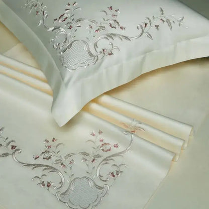 Cream-colored satin pillowcase with intricate silver and rose-gold floral embroidery from decorbites elegant flowers bedding set