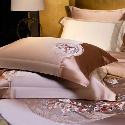 A blush pink satin pillowcase with elegant flowers embroidery in rose gold featuring a brown satin accent panel