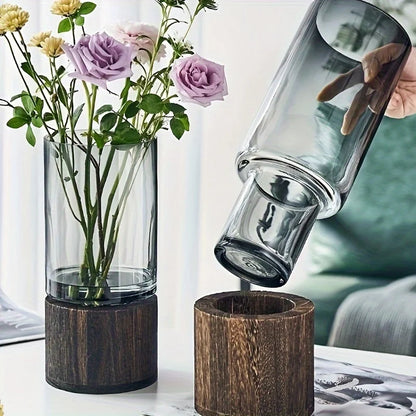 Elegant glass vase with dark wood base holding purple and yellow flowers for modern hydroponic tabletop decor