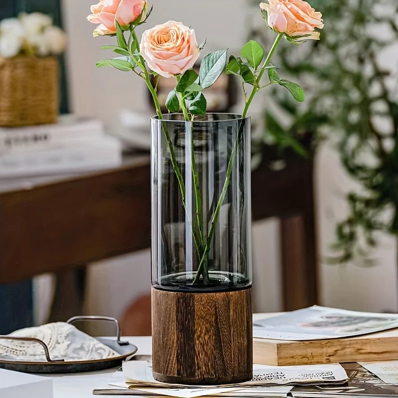 Elegant glass vase with dark wood base holding peach-colored roses for modern hydroponic tabletop decoration
