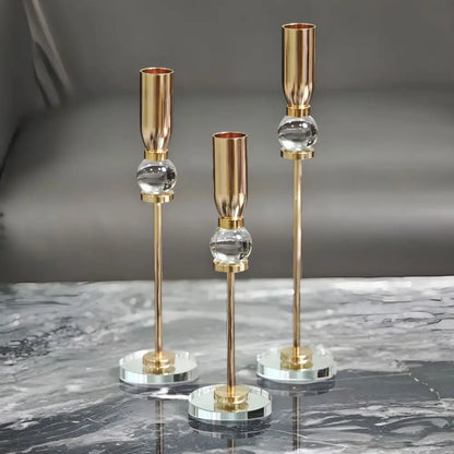Set of three elegant gold-toned decorbites crystal glass candlestick holders with clear spheres and mirrored bases for dining room decor