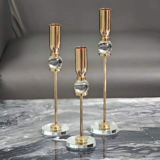 Set of three elegant gold-toned decorbites crystal glass candlestick holders with clear spheres and mirrored bases for dining room decor