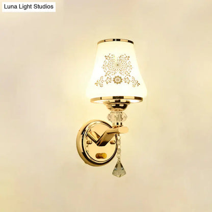 Elegant gold and white crystal wall light with ornately patterned glass shade and dangling crystal accents for reading wall light