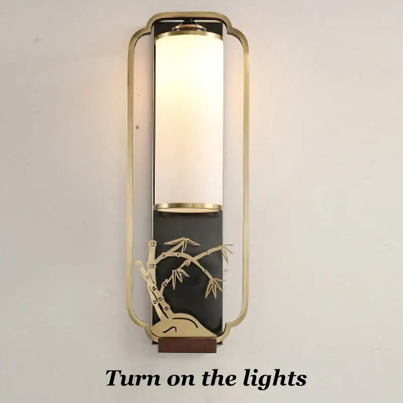 Elegant gold bamboo iron glass wall sconce with frosted glass cylinder and black accent panel for living room