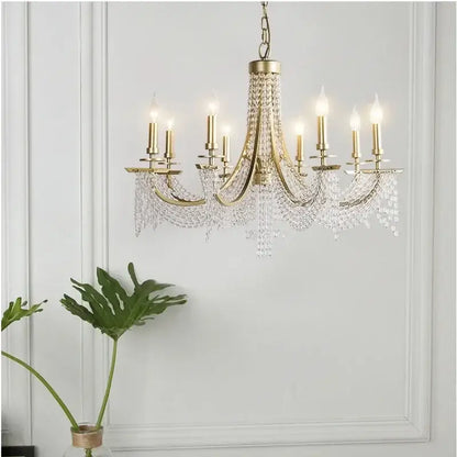 Elegant gold crystal candle chandelier with multiple arms and cascading clear droplets by decorbites for dining room decor