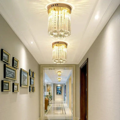 Elegant gold crystal ceiling light with vertical glass prisms and circular brass base for decorbites elegant crystal hallway decor