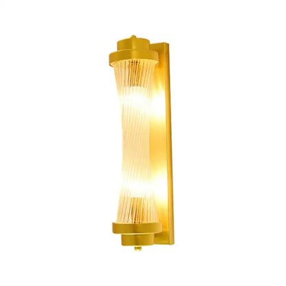 Elegant gold wall sconce light with cylindrical glass shade and vertical translucent rods for living room lighting