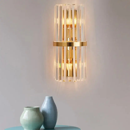 Elegant gold wall sconce light with vertical crystal rods and central circular accent for living room lighting