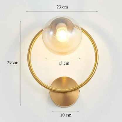 Elegant gold iron wall lamp with circular frame and clear glass globe designed as a modern decorbites iron wall lamp