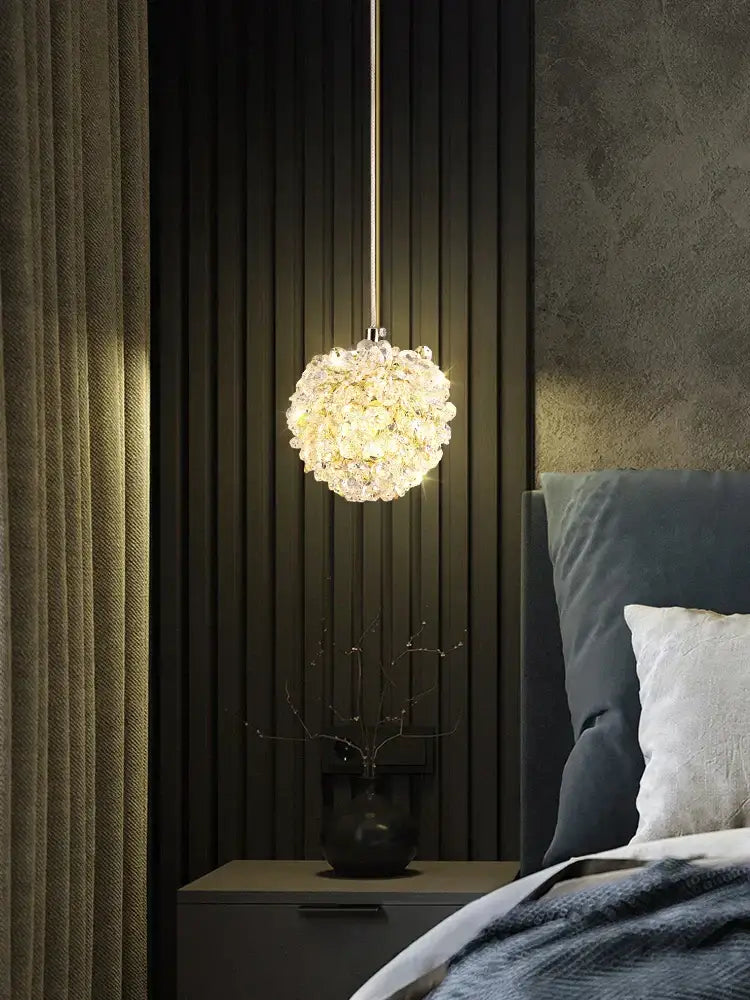 A spherical gold metal crystal pendant light from decorbites with warm glowing light for dining room decor