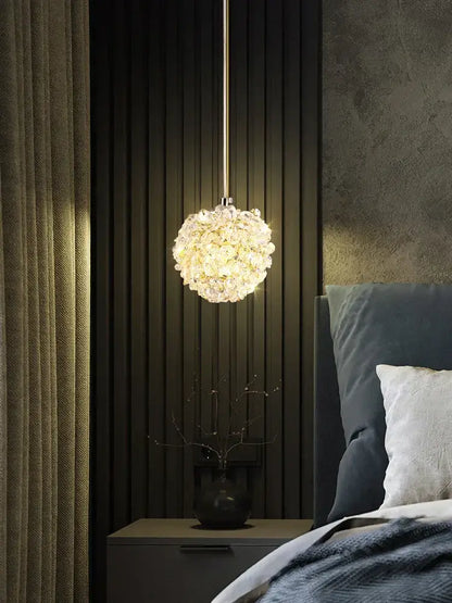 A spherical gold metal crystal pendant light from decorbites with warm glowing light for dining room decor