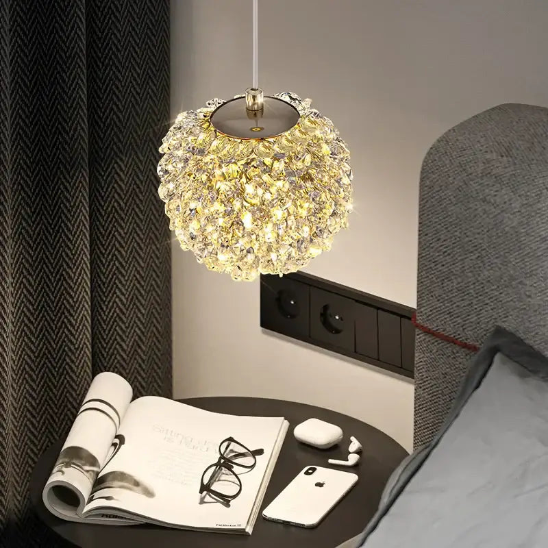 A sparkling gold metal crystal pendant light with spherical clustered design hanging for dining room decorbites gold metal