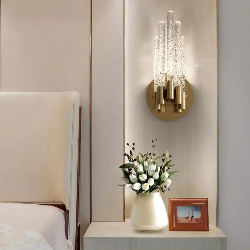 Elegant gold metal wall sconce with five textured crystal glass arms radiating light for bedroom decorbites gold metal