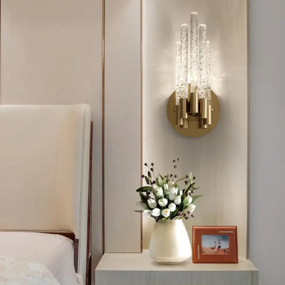Elegant gold metal wall sconce with five textured crystal glass arms radiating light for bedroom decorbites gold metal