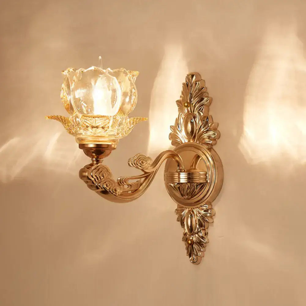 Elegant gold scrolled arm wall mount sconce featuring an ornate design and crystal glass tulip-shaped shade for bedrooms