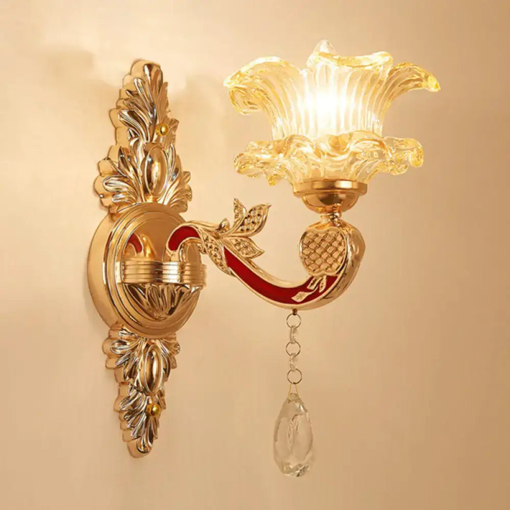 Elegant gold scrolled arm wall mount sconce with amber glass flower shade and crystal teardrop for bedroom lighting