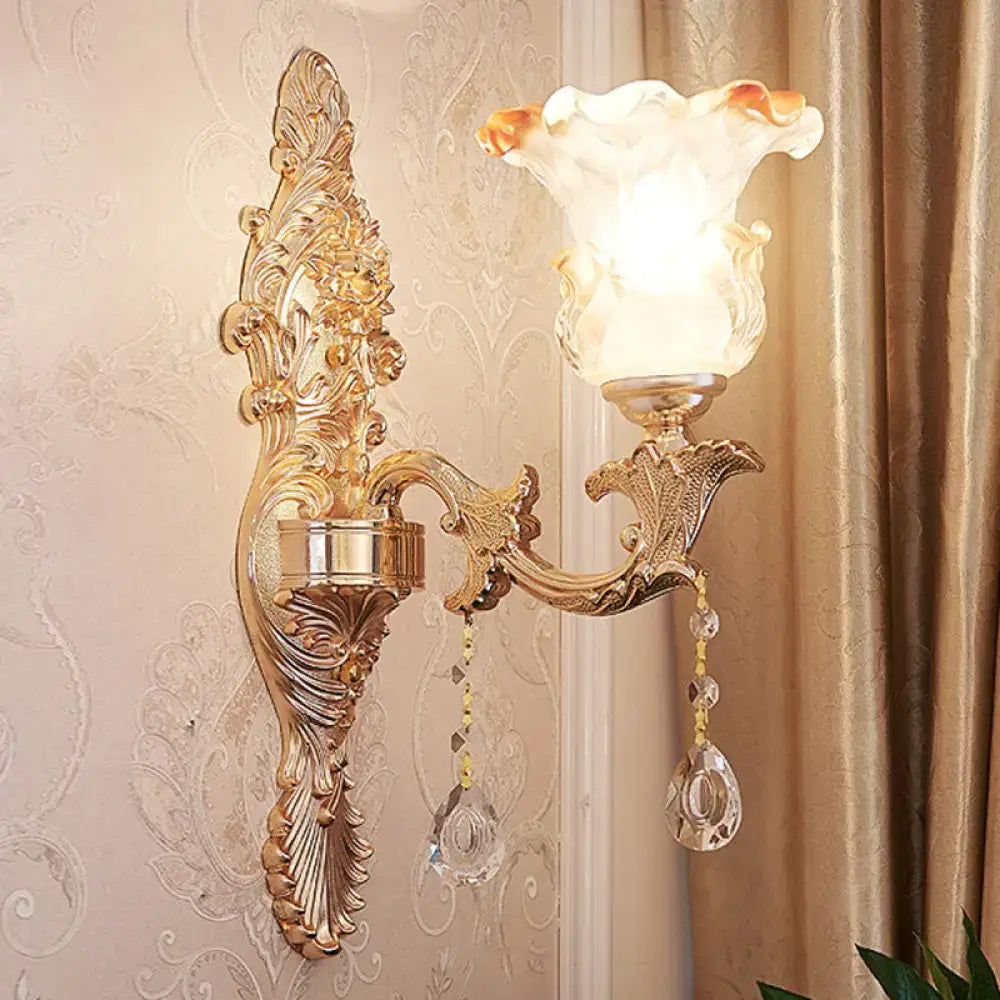 Elegant gold scrolled arm wall mount sconce with frosted glass lampshade and dangling crystal beads for bedroom lighting