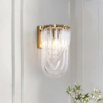 Elegant gold wall lamp with twisted crystal shade featuring a gold metal frame and cascading clear glass tubes for bedroom