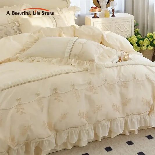 Cream-colored satin bedding set with delicate ruffles embroidered floral patterns and scalloped edges decorbites elegant heart