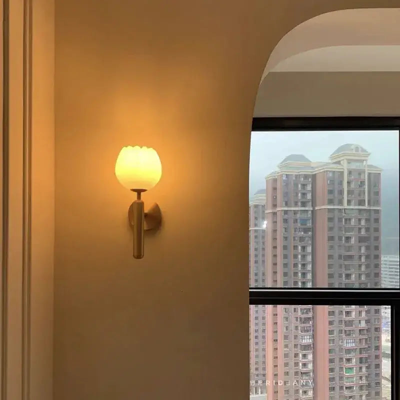 Elegant lotus gold and marble wall lamp with warm-toned frosted glass sconce and sleek metallic base for bedroom