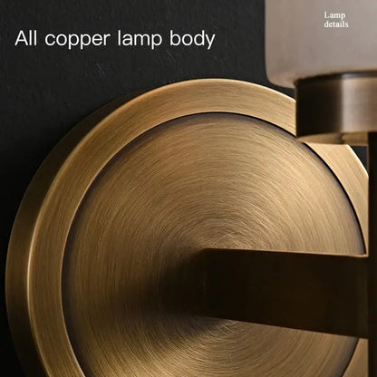 Brass-finished copper wall sconce with circular brushed metal base and sleek arm for decorbites elegant marble copper lighting