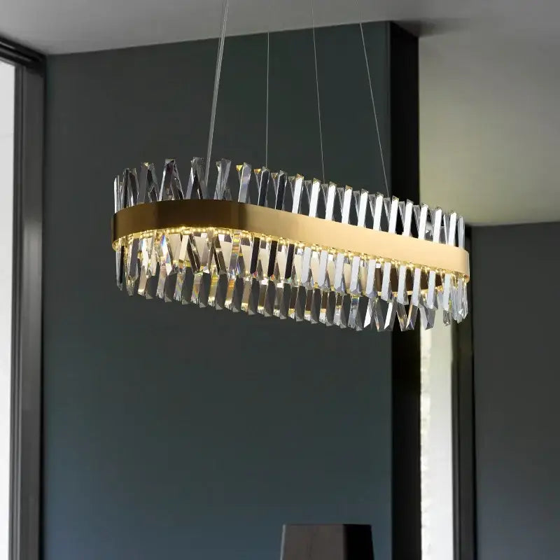 Elegant oval crystal chandelier with decorbites brushed gold rings and cascading clear crystal prisms for dining room light