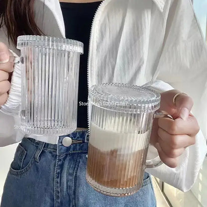 Elegant clear ribbed glass straw cup with matching lids and handles featuring a layered drink by decorbites glass