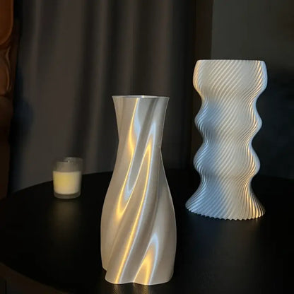A sleek silver-toned vase with a smooth twisted flowing design for decorbites elegant high-end living room decor