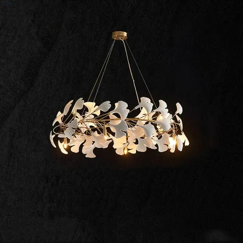 A modern white and gold ceramic chandelier with delicate ginkgo branch leaves for elegant dining room decorbites decor