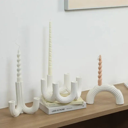 Elegant white ceramic candlestick holder with curved ribbed design and spiral-topped candles for dining room decorbites decor