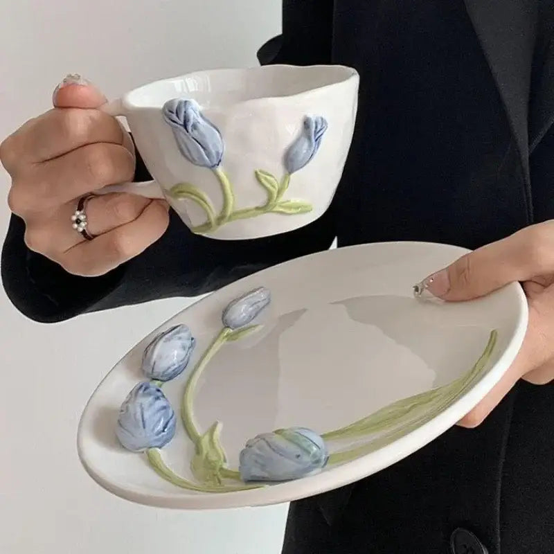 White embossed tulip ceramic coffee cup and matching oval plate with raised blue flowers and green stems decorbites 3d embossed