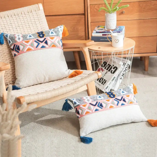 Embroidered blue tufted pillow cover with geometric embroidery in pink blue and orange hues and colorful tassels