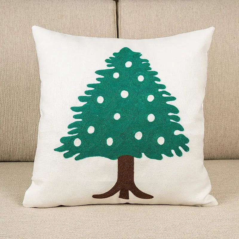 White cushion cover featuring decorbites embroidered christmas tree with green pine and brown trunk for living room decor