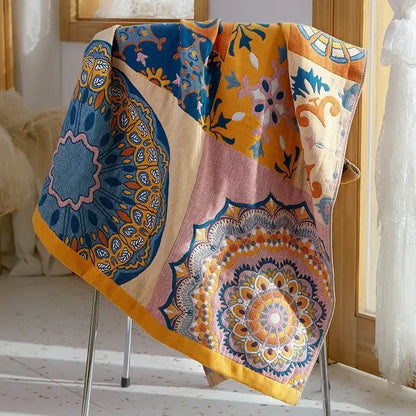A vibrant patchwork bath towel with intricate mandala patterns in blue yellow pink and orange made of soft cotton gauze bath towels decorbites cotton gauze