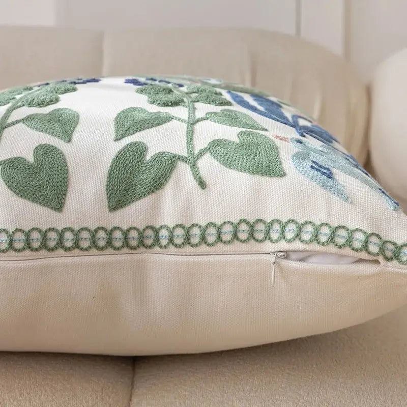 Cream-colored office cushion pillowcase with intricate green and blue embroidered foliage design for office use