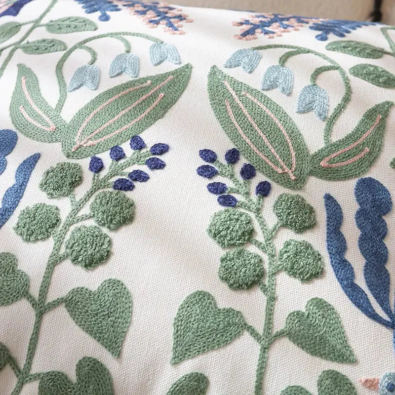 Cream-colored office cushion pillowcase with intricate embroidered floral patterns in green blue and pink for office use