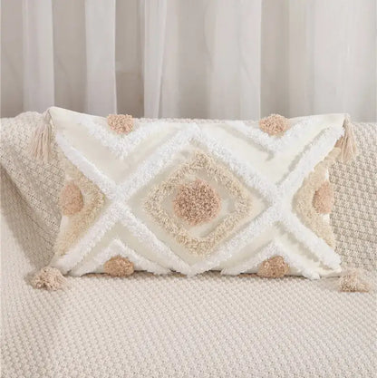 Cream-colored textured pillow cover with embroidered geometric leaves pattern and fluffy pom-poms for living room decor