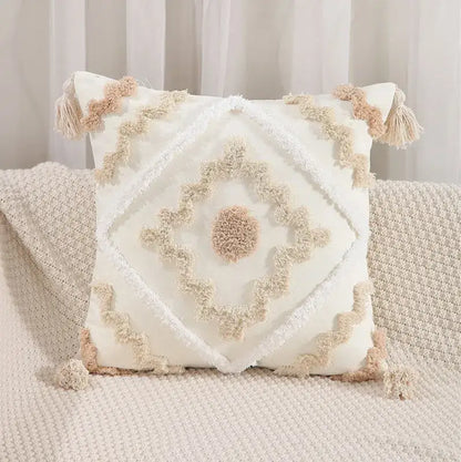 Cream-colored pillow cover with embroidered geometric leaves design and tasseled textured detailing for living room decor