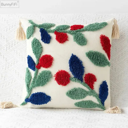 Cream-colored pillow cover with embroidered geometric leaves featuring red and blue berries and beige tassels for living room decor