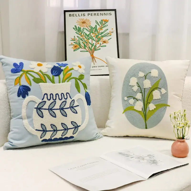 Light blue square pillowcase featuring a white embroidered vase with blue and green floral decorbites blue hyacinth design