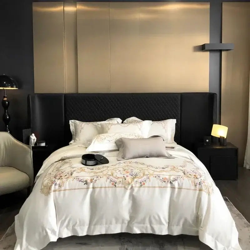 White satin egyptian cotton bedding set with gold floral embroidery and quilted black headboard backdrop
