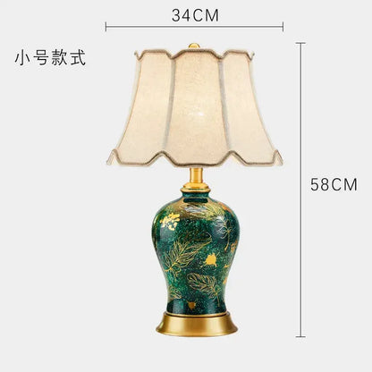 Emerald green floral ceramic table lamp with decorbites golden leaf patterns and a cream pleated shade for living room decor