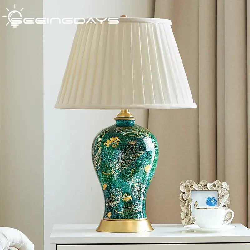 Emerald green floral ceramic table lamp with decorbites golden leaf and pleated cream shade for living room decor