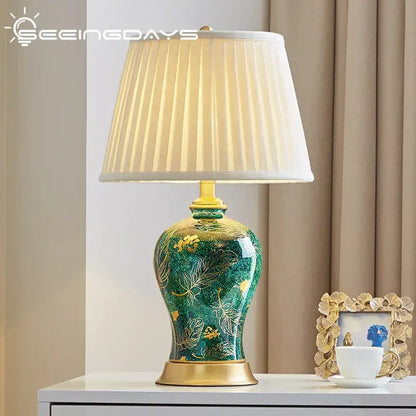 Elegant emerald green ceramic table lamp with gold accents and cream shade featuring decorbites golden leaf patterns