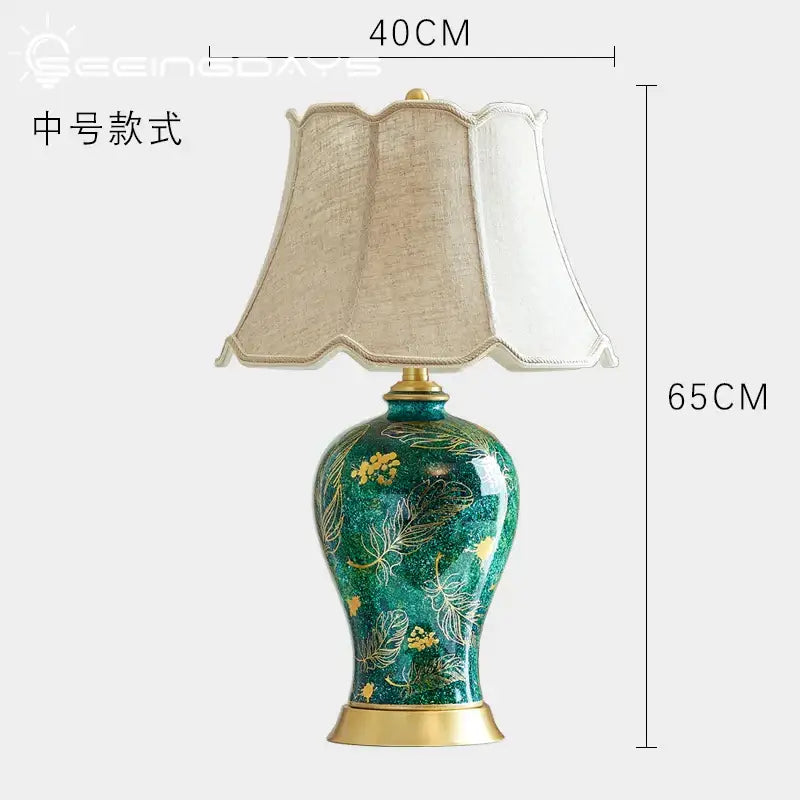 Emerald green floral ceramic table lamp with decorbites golden leaf patterns and a beige fabric shade for living room decor