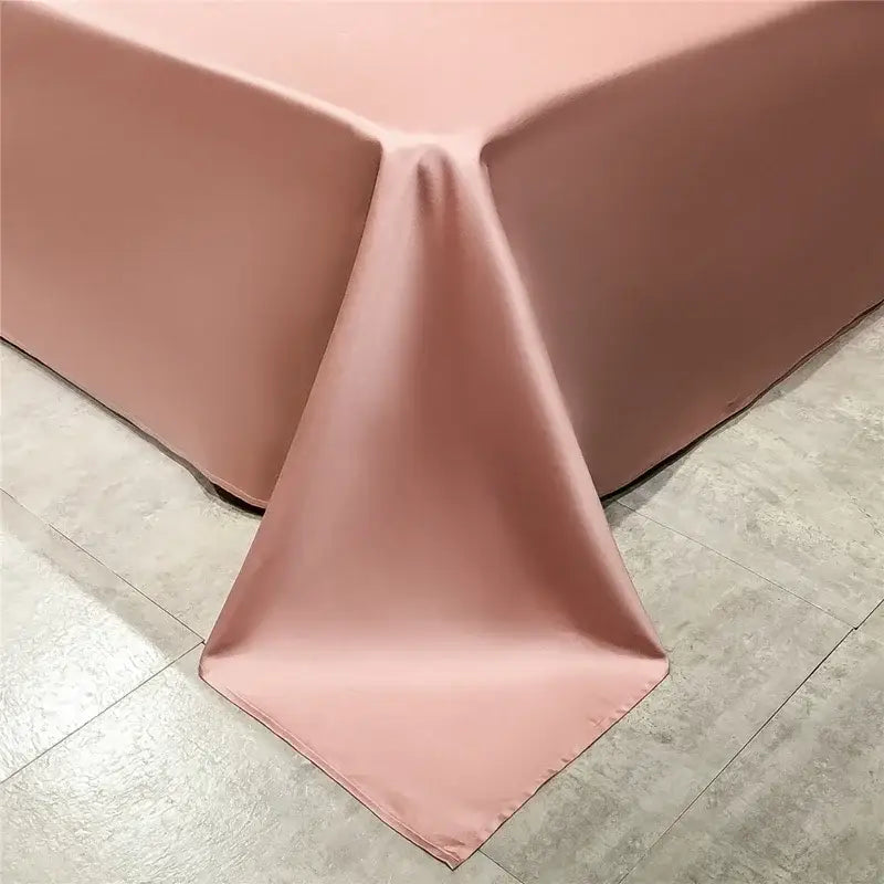 A smooth blush pink satin bed skirt complements the emerald green and pink egyptian cotton bedding set