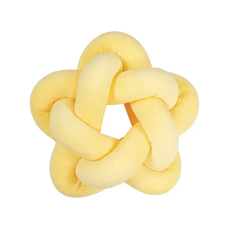 Yellow plush knot-shaped toy shown alongside emerald green star velvet lumbar cushion by decorbites green star decor