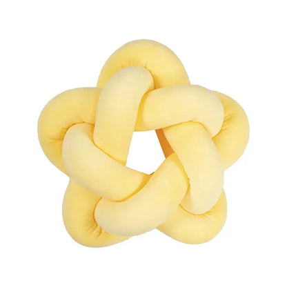 Yellow plush knot-shaped toy shown alongside emerald green star velvet lumbar cushion by decorbites green star decor