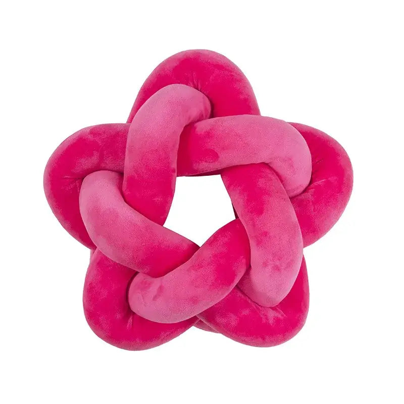 A plush vibrant pink velvet knot-shaped decorative pillow contrasting with the decorbites green star lumbar cushion