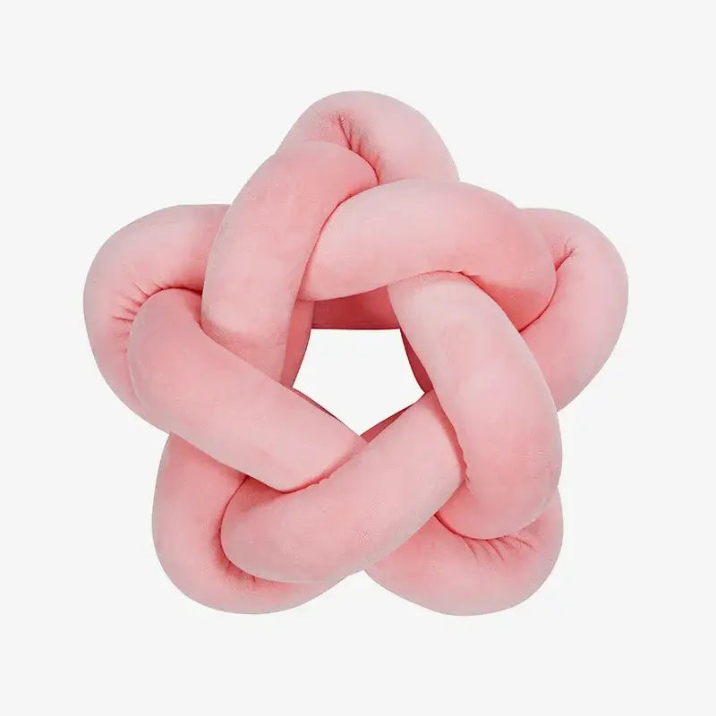 A pastel pink plush velvet lumbar cushion shaped like an interwoven knot for decorbites green star bedroom decor